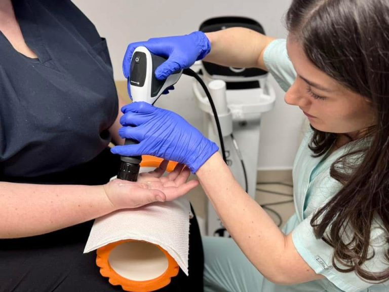 Terapeută aplicând terapie cu unde de șoc unui pacient la clinică de recuperare medicală din Fălticeni.